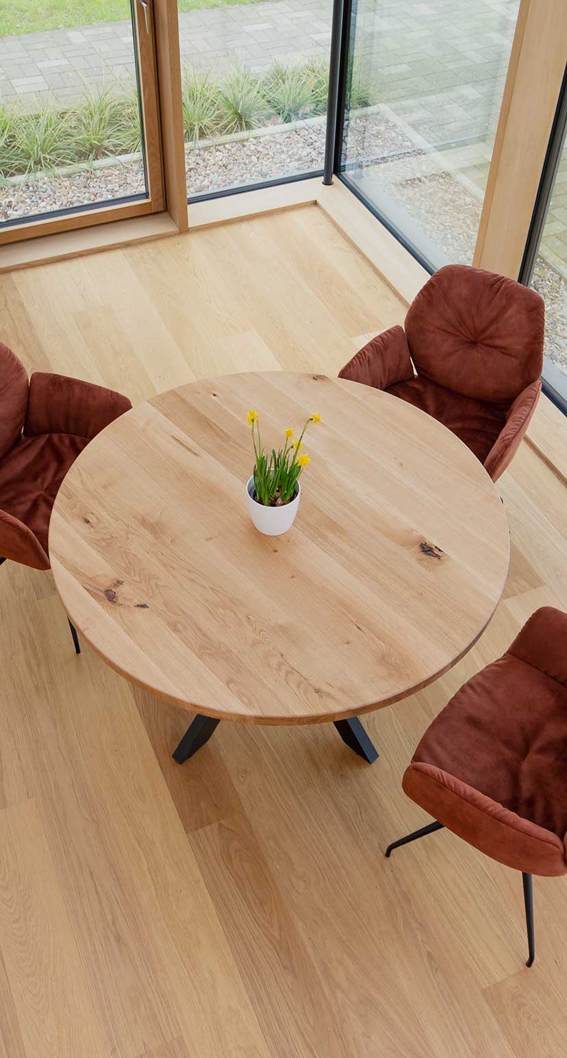 Runde Tischplatte Eiche Astig mit Deko und roten Stühlen