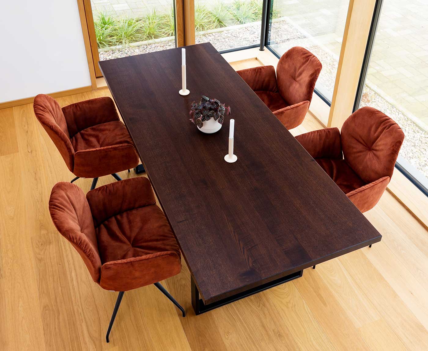 Tischplatte Walnuss mit Deko und vier roten Stühlen