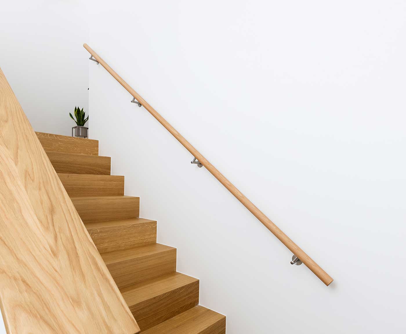 Langer runder Handlauf aus Buche in Massivholz auf der Treppe