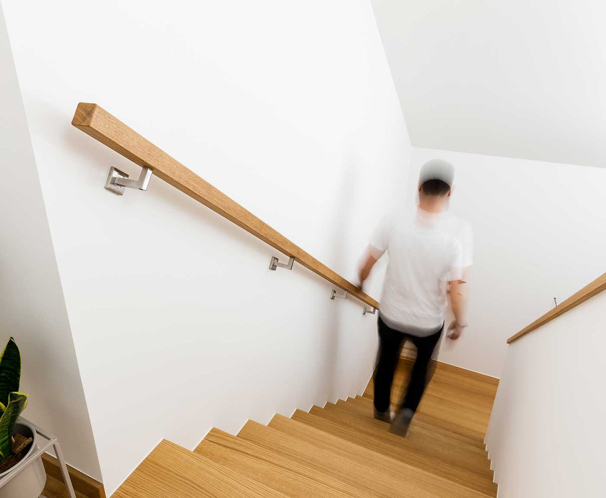 Quadratischer Handlauf aus Eiche mit Person auf der Treppe