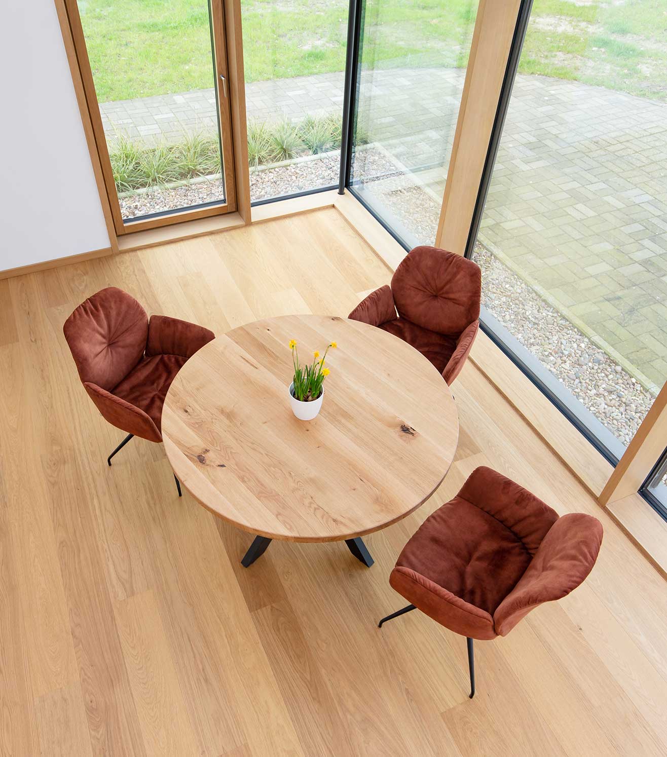 Runde Tischplatte Eiche mit Deko und roten Stühlen