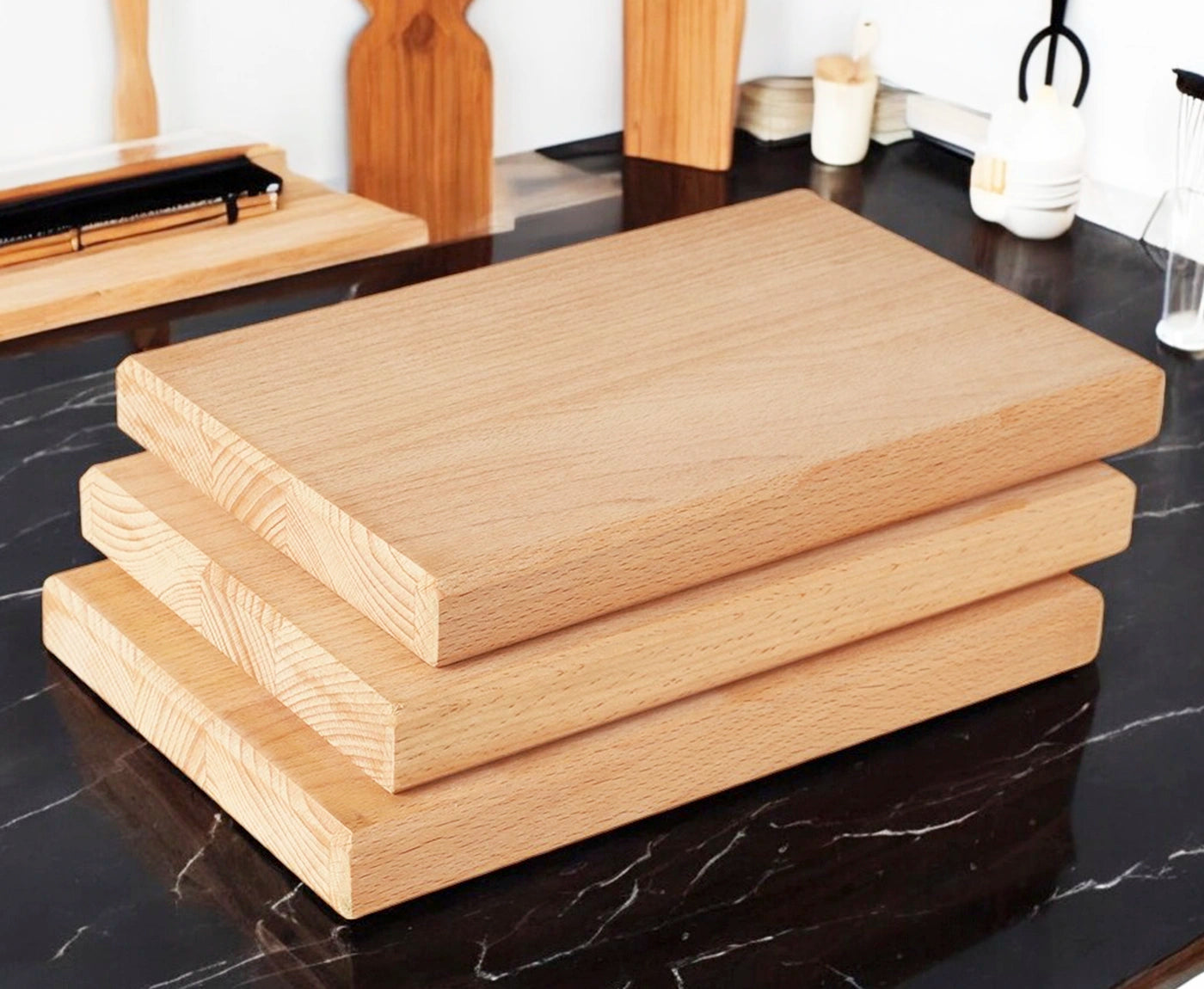 Drei Frühstücksbretter, Brotzeitbretter aus Buche auf schwarzer Arbeitsplatte.