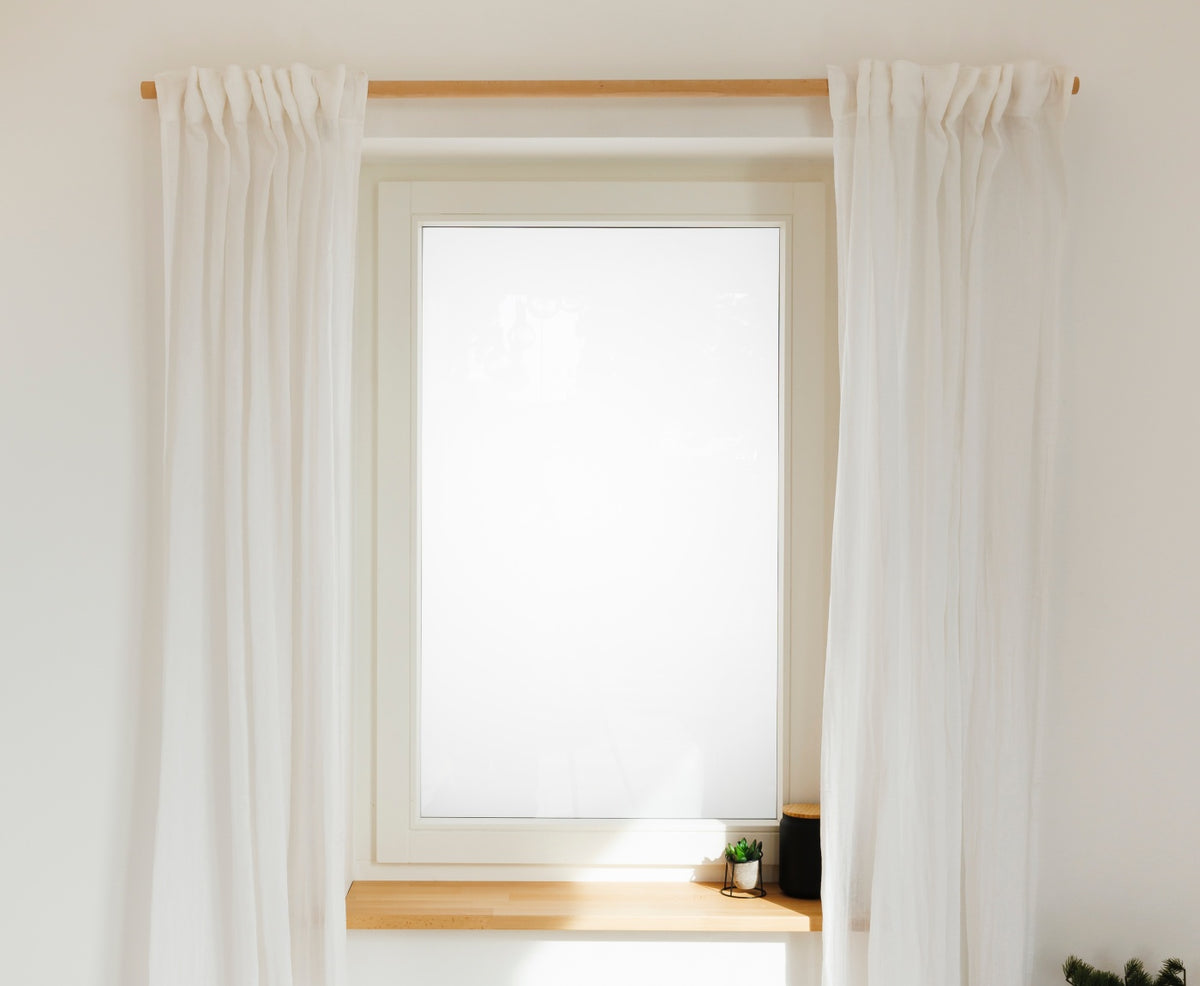 Fenster mit weißen Vorhängen an Gardinenstange aus Buche, mit Fensterbrett aus Buche und Dekoration