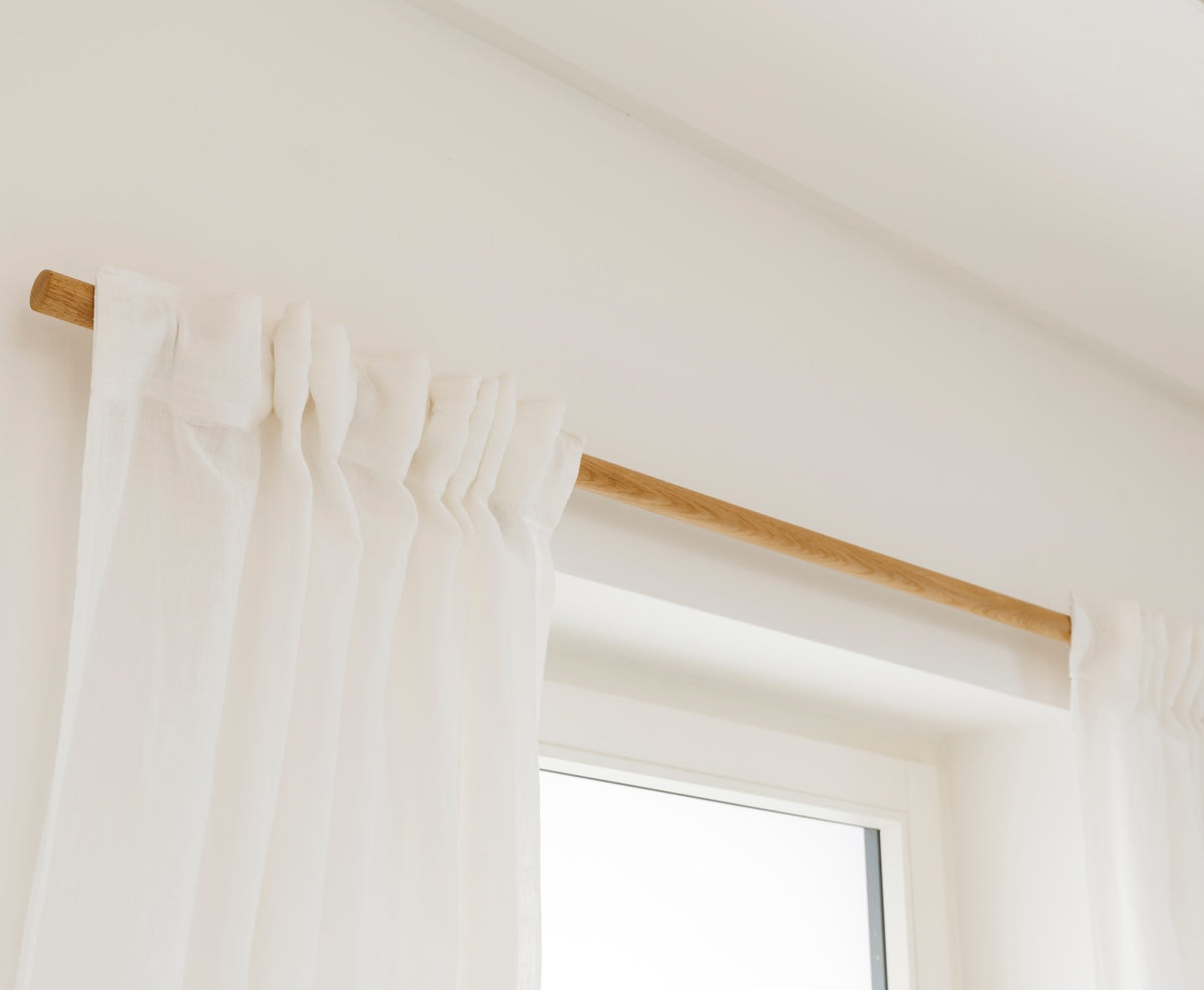 Seitlicher Blick auf Gardinenstange Eiche mit weißen Vorhängen und Ausschnitt von Fenster