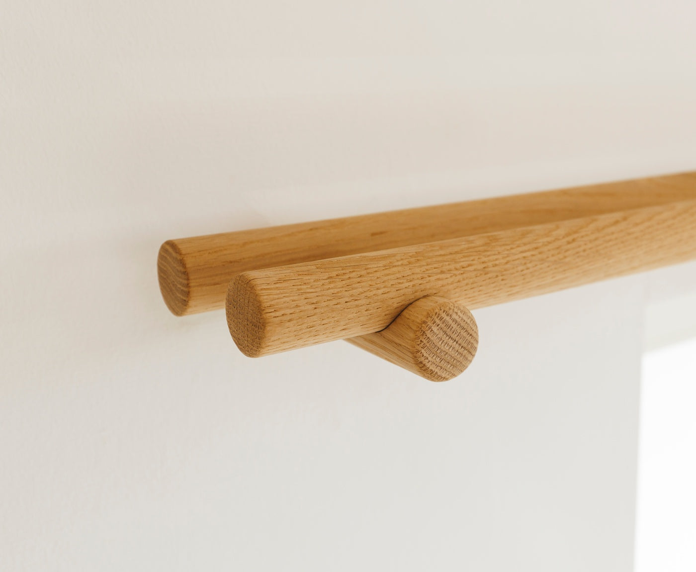 Detailbild von Enden und Halterung der doppelten Gardinenstange aus Eiche massiv