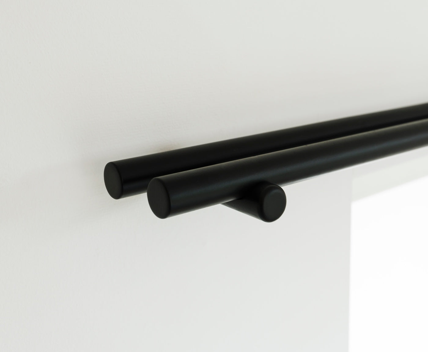 Nahaufnahme von Enden der doppelten Gardinenstange und Halterung