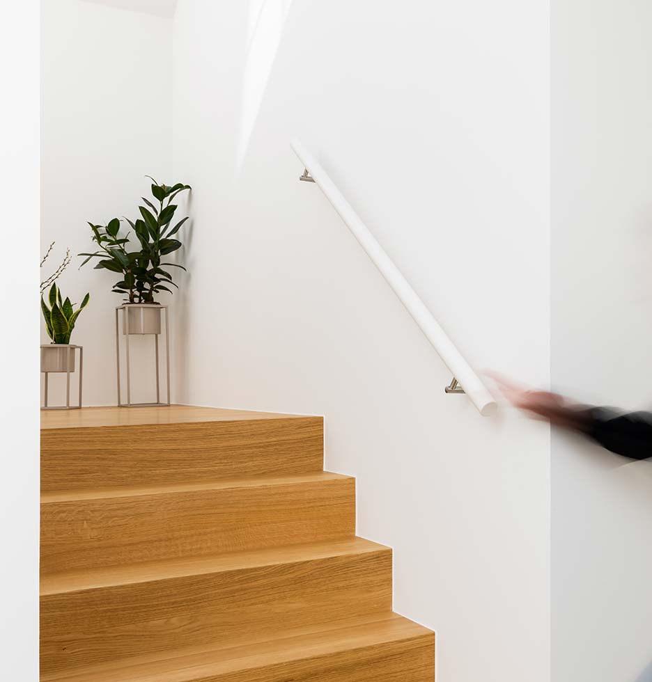 Weißer Handlauf in einem Treppenaufgang