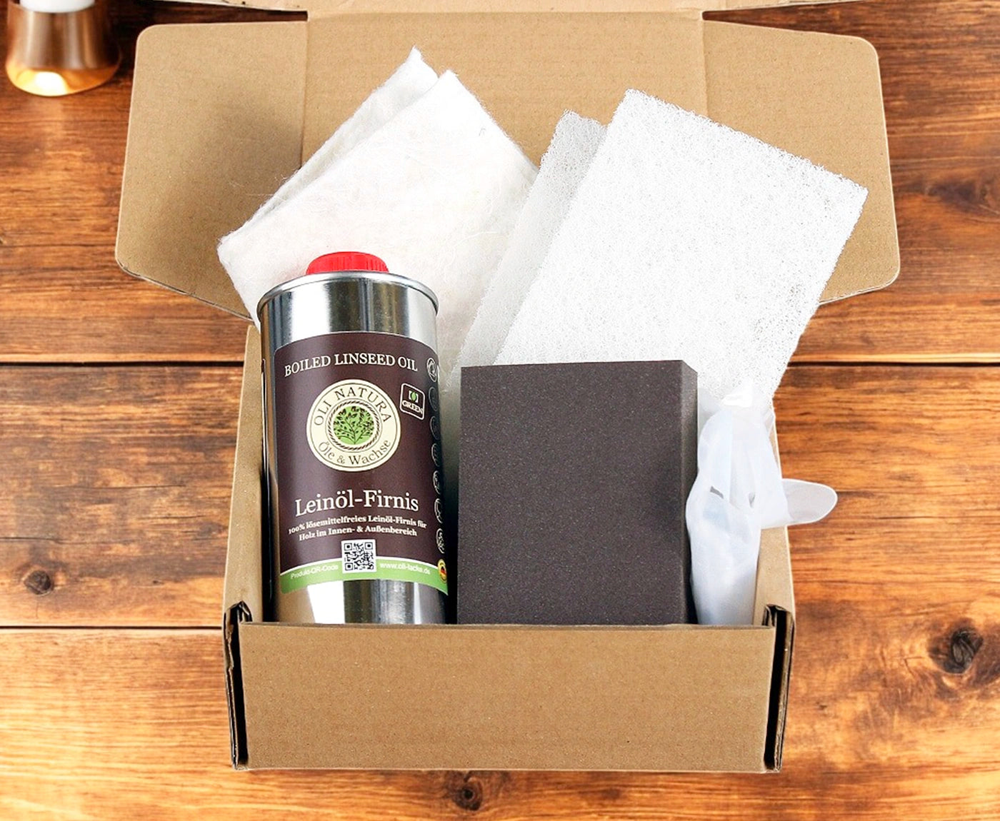 Versandkarton mit Leinöl-Firnis, sowie verschiedenen Schwämmen für die Schneidebrett-Pflege.