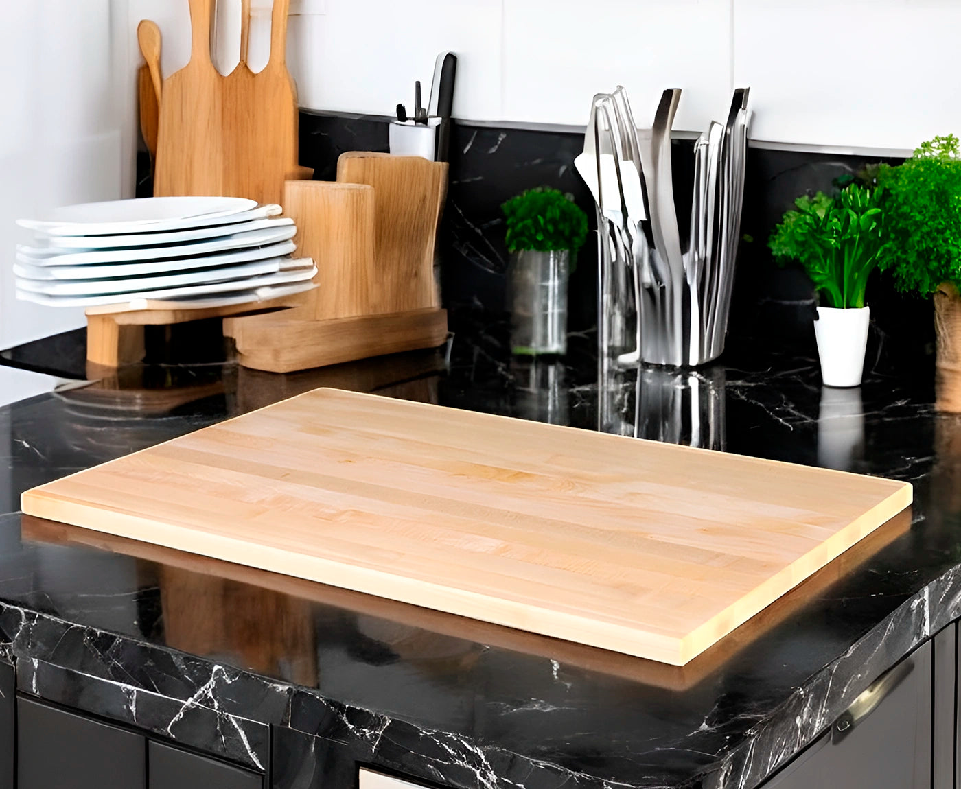 Kochfeldabdeckung aus Ahorn auf schwarzer Küchenzeile, mit Küchenutensilien.