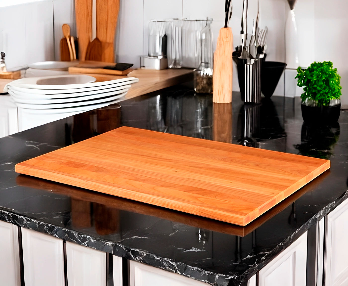Kochfeldabdeckung aus Kirschbaum auf schwarzer Arbeitsplatte.