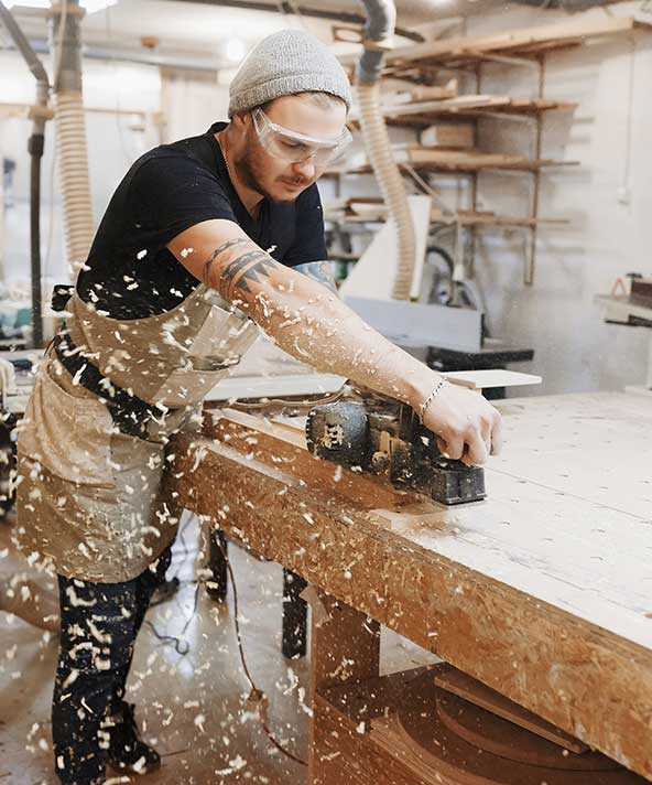 Junger Mann sägt ein Brett